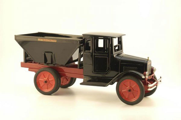 BUDDY "L" COAL TRUCK WITH DOORS: c. 1930, pressed steel, enclosed black cab with fully opening doors, hopper body has sliding discharge doors, dual rear tires, metal embossed disc wheels painted in red. 25" l.