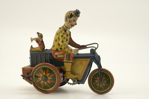 FISCHER CLOWNS ON MOTORCYCLE: Germany, c. 1930, one of the most colorful and whimsical of the cycle toys, depicts large seated clown with articulated leg action, small clown seated on rear with horn in mouth, great clockwork actio