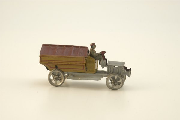 MILITARY PENNY TOY TRUCK: Meier, Germany, canopy covered truck painted grey, yellow and red; solo driver, spoke wheels, fly wheel mechanism, dog and cart logo appears on back end. 4 1/2" l.