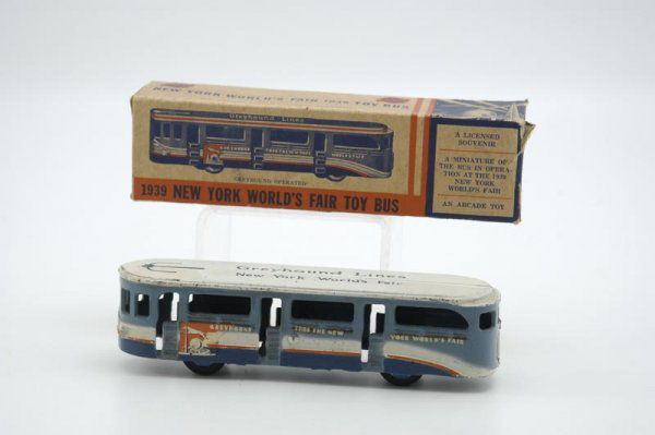 ARCADE BOXED 1939 WORLD'S FAIR BUS: Cast iron, painted in familiar blue and white roof, stenciled "New York World's Fair," very colorful fair theme, color decals on sides, box as colorful as toy. 8 1/4" l.