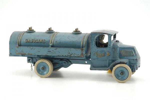 ARCADE MACK GASOLINE TRUCK: c. 1925, cast iron, blue body overall with gold highlights, embossed "GASOLINE" on tank, enclosed Mack body has seated nickeled driver, fill caps cast at tank top, rubber tires, blue disc wheels, well