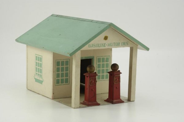 ARCADE FILLING STATION: c. 1930's, wood garage done in green roof, white sides, canopy covers two cast iron fuel pumps with embossed dials, fa?ade stenciled "Gasoline - Motor Oils," decal on gable, side bay door opens. 10" x