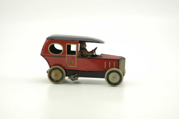 GUNDKA & KELPERT LIMOUSINE: Germany, c. 1920's, lithographed tin, red body, black roof, circular passenger windows, slant rear, seated driver, clockwork driven. 6 1/2" l.