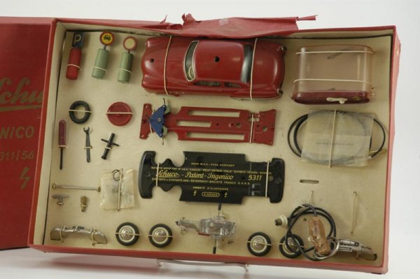 BOXED SCHUCO 5311/56 MK DELUXE SET: Unplayed with 5311 auto with full accessories, each still strung in box, varied pieces, auto done in red, clockwork driven. 13" x 19".