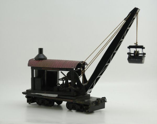 BUDDY "L" OUTDOOR RAILROAD DREDGE: 1922, locomotive dredge done in black crane housing, red corrugated roof, well designed lever controlled action, long boom with clam shell bucket on string pull, flat car frame features stablizer exte