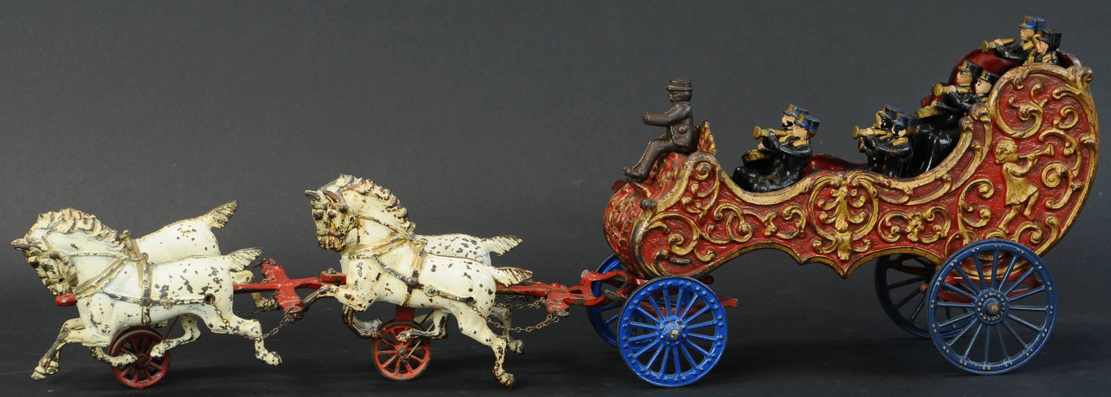 LARGE HUBLEY BAND WAGON: 64. LARGE HUBLEY BAND WAGON | Larger of two sizes produced, this colorful toy has nice superb casting effects on the wagon, contains a full marching band seated with instruments in hands, drawn by a t