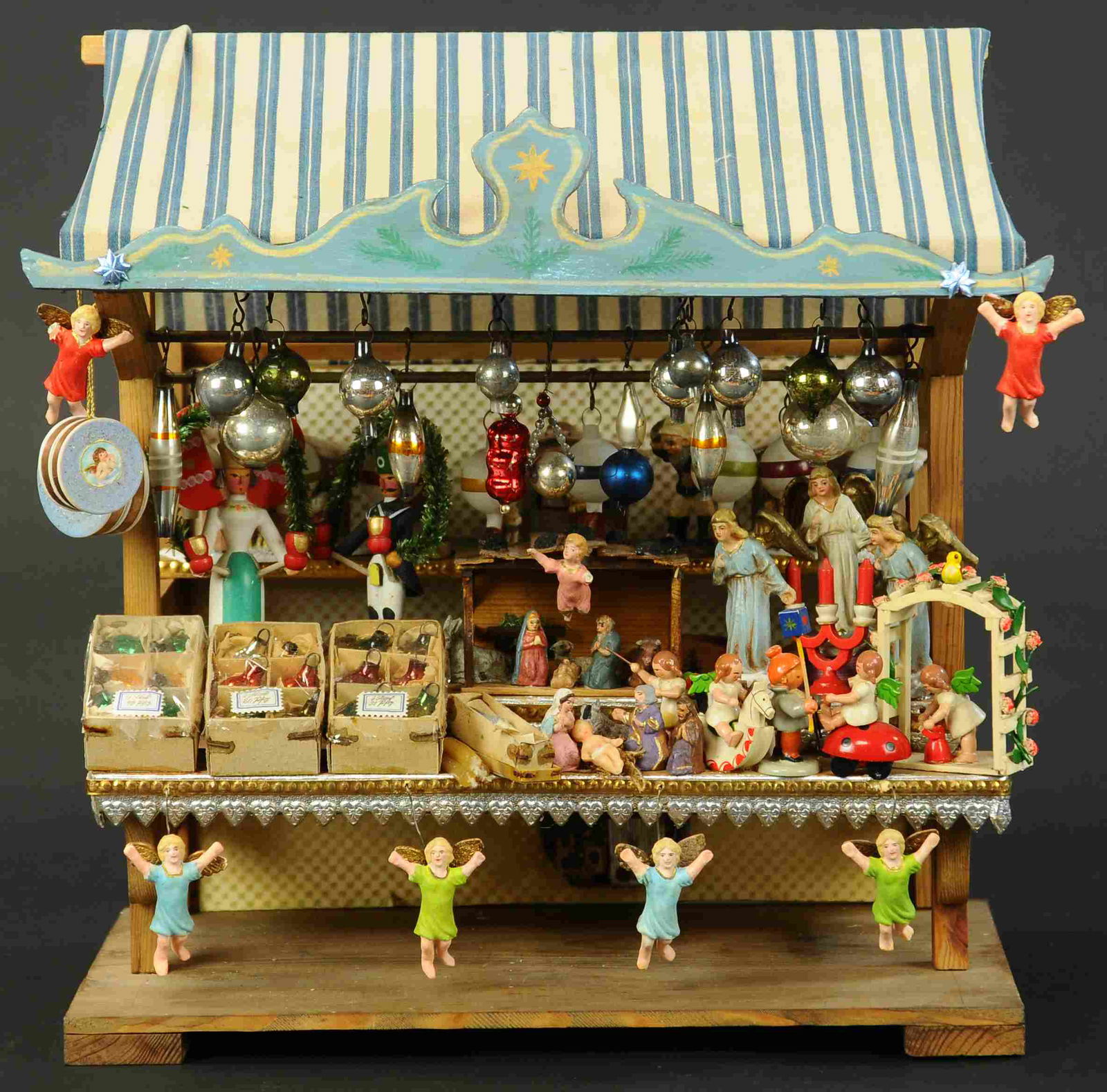 AN OUTSTANDING LOOKING CHRISTKINDLMARKT: 231. AN OUTSTANDING LOOKING CHRISTKINDLMARKT | A hard to find miniature German Christmas Market stand/music box, the market is loaded w/wonderful Christmas gifts, some are composition, some Erzgebirge