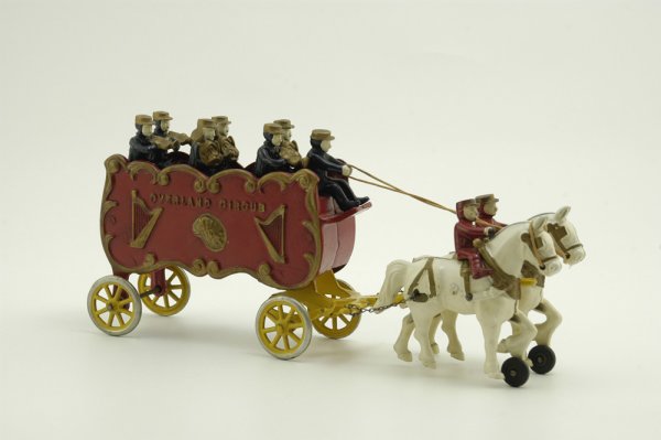 KENTON CIRCUS BANDWAGON: Cast iron, ornate open bed wagon features bench seating with full compliment of seated musicians, drawn by white horses, a classic depiction of early parade wagons. 15 1/2" l.