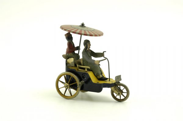 LEHMANN NEW CENTURY CYCLE: Germany, lithographed tin, hand painted, seated figure holding tiller bar while attendant holds tin lithographed umbrella marked ''345'' on top overhead, clockwork driven. 5''l.