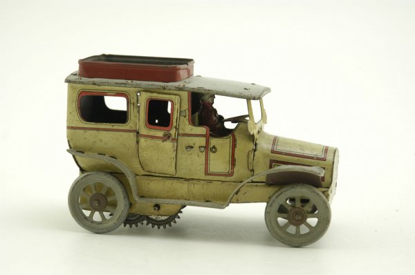 OROBR LIMOUSINE: Germany, lithographed tin, done in white and red, luggage rack on roof, seated driver, clockwork driven, doors open. 5 3/4" l.