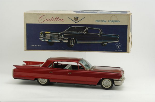 1962 BOXED CADILLAC FOUR-DOOR HARDTOP: Yonezawa, Japan, beautifully scaled and painted in eye catching red body overall, rubber tires, friction driven, lithographed interior seating, celluloid windshield. Impressive at 22" l.