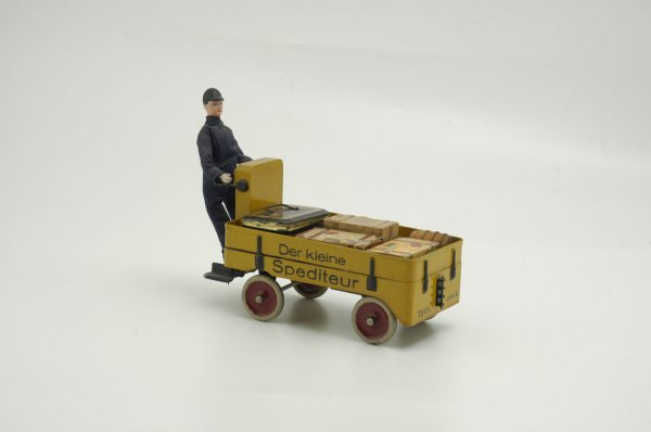 MARKLIN LUGGAGE CART WITH DRIVER: Germany, clockwork driven, elaborate cart done in yellow, red wheels, sides read "Der Kleine Spediteur." 8 1/2" l.