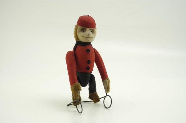SCHUCO TUMBLING MONKEY: 1920, Germany, billed as the "Acrobat Messenger," amusing felt suited bellhop monkey, stands on wire frame and able to seemingly tumble when body is wound which conceals clockwork. 10 3/4" h.