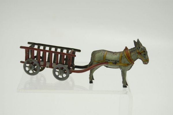 HAY WAGON PENNY TOY: Meier, lithographed tin, donkey pulls four-wheeled cart painted red w/gray spoke wheels. 6 1/4" l.