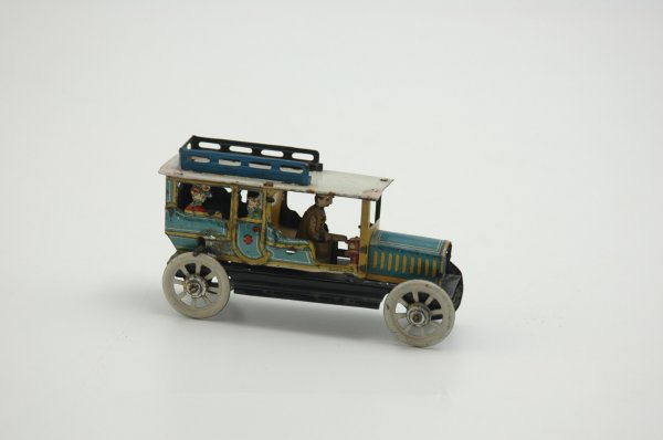 DISTLER LIMOUSINE PENNY TOY: Colorful piece, large limo carries several passengers, die-cut at window; blue luggage rack, fly-wheel operation. 4 1/4" l.