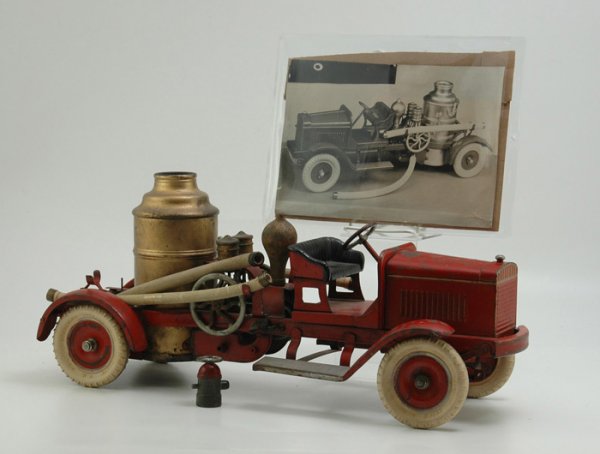 KINGSBURY FIRE PUMPER: Pressed steel, done in red service body, vertical boiler, hose supports on sides, embossed bench seating, red disc wheels, white rubber tires, 100% complete making this a rare find. 22 1/2" l.