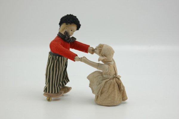 GERMAN WIND-UP TOY: Young boy holding younger sister's hand, dressed in Dutch style clothing with pressed felt faces and arms, probably Bing, dolls spin in circular motion when wound. Boy 9 1/2" h.