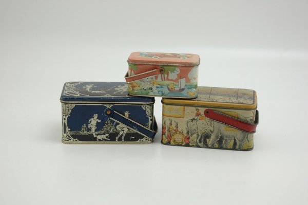 LOT OF THREE BOX CANDY TINS: All done in tin lithography, includes graphic images of circus, children and animals, each with handle. 4 1/2" to 6 1/8".