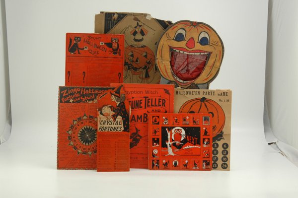 GREAT HALLOWEEN PAPER AND GAME LOT: Nice assortment of lithographed paper and cardboard items including spinner games, wooden jack-o-lantern bean bag target, old Kresge costume box (tattered), and more. Largest 10 1/2" x 12".
