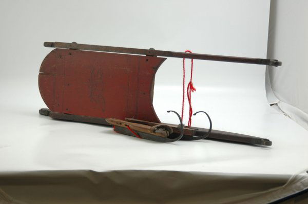 VERY EARLY ICE SKATES AND CHILD'S SLED: Lot includes a great early pair of wooden ice skates with metal runners that curl up over the toe area, and a metal spike in the heel for holding shoes in place, remnants of leather straps remain; als