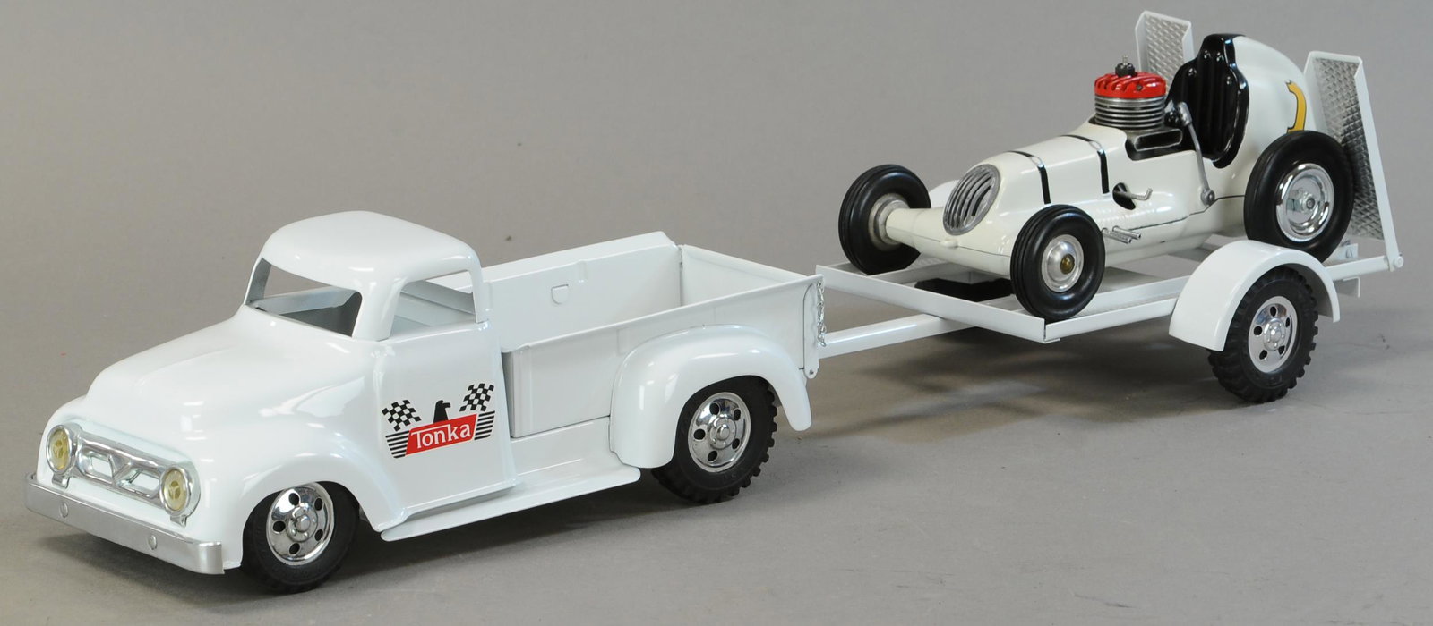 TONKA TRUCKW/ THIMBLE DRONE RACER TRAILER: 1527. TONKA TRUCKW/ THIMBLE DRONE RACER TRAILER | 24" l. | Contemporary w/ Thimble Drome race car. | $300 - $600
