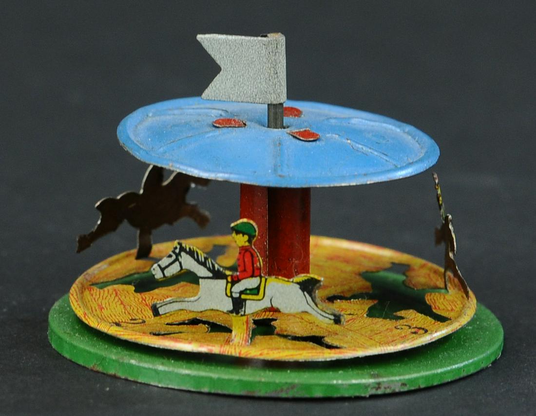 HORSE RACE CARROUSEL PENNY TOY: 136. HORSE RACE CARROUSEL PENNY TOY | Provenance: Paul Cole Collection. | 3" l. | (Excellent Condition) | $300 - $600