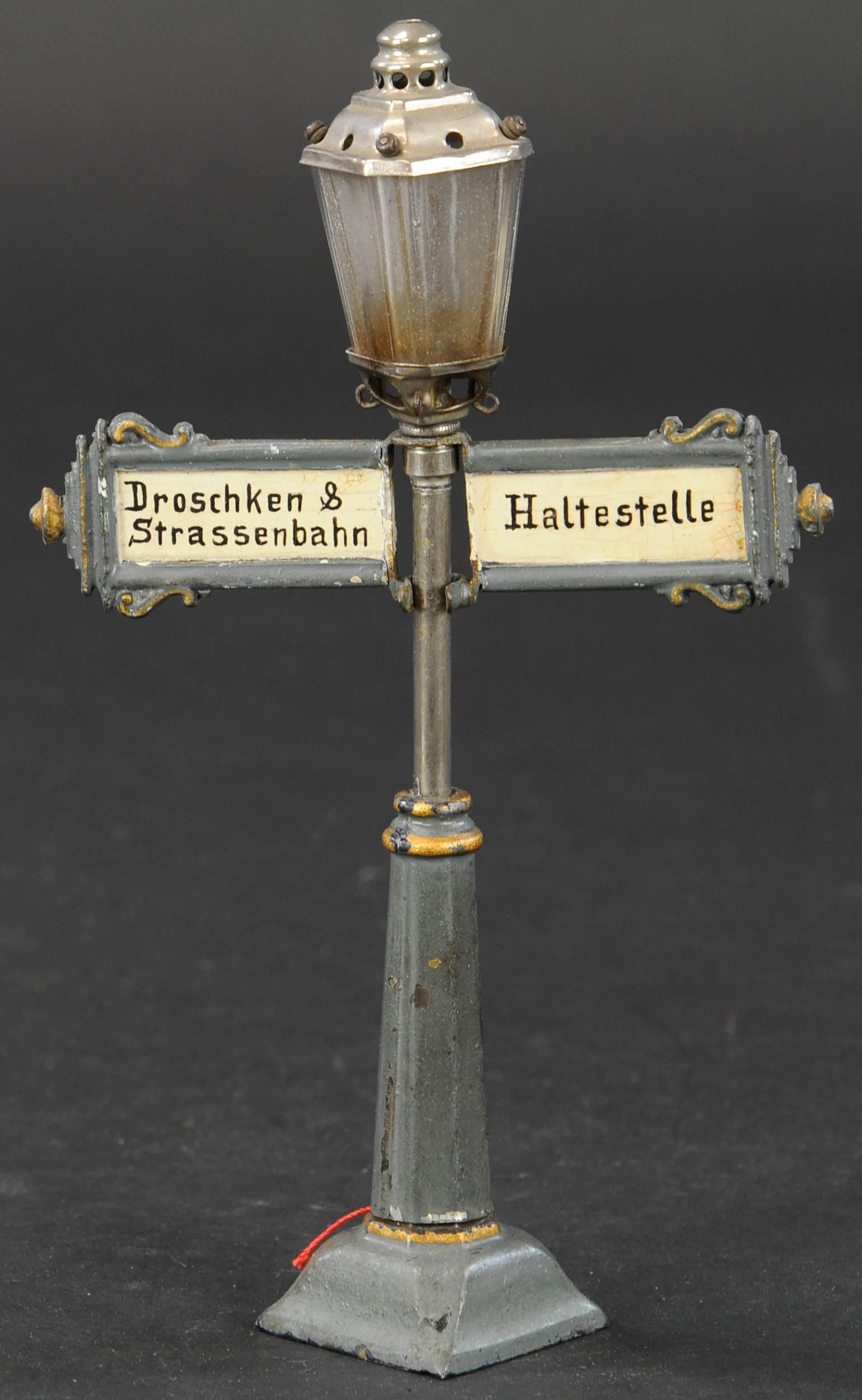 RARE MARKLIN "TRAM, TAXI & BUS STOP" LAMP POST: 760. RARE MARKLIN "TRAM, TAXI & BUS STOP" LAMP POST | Hand painted, rare lamp post with signs that read "Droschken, Strassenbahn, Haltestelle," which translates to "Cab, Trolley, Bus Stop," catalog no