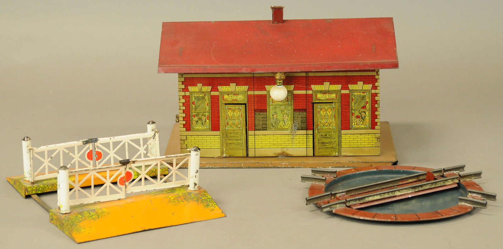 IVES PASSENGER STATION WITH GERMAN ACCESSORIES: 447. IVES PASSENGER STATION WITH GERMAN ACCESSORIES | Ives litho station, hand painted Bing track crossing and Marklin round table. | 13" l. | All Original Condition. | $200 - $400