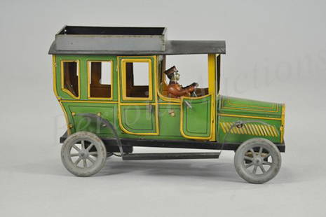 FISCHER SEDAN: Germany, lithographed tin, done in green body with yellow striping, seated driver, luggage rack, spoke wheels, clockwork driven, opening doors. 10" l.