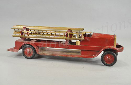 TURNER TOYS FIRE LADDER TRUCK: c. 1920's, pressed steel, painted in red overall, low open cab and service frame body, holds three gold ladders, nickeled bell behind driver's seat, rubber tires, metal wheels. 27" l.