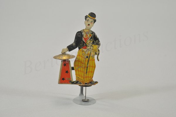 CHARLIE CHAPLIN CYMBAL PLAYER: Litho tin squeeze toy. Charlie holds cat and bangs cymbals when squeezed. Distler trademark, made in Germany circa 1920. 7" h.