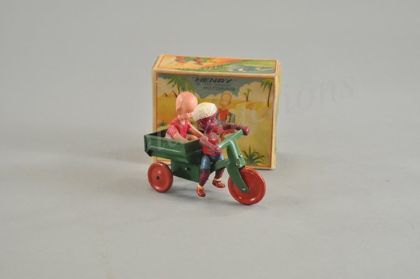 HENRY MOTORING IN ORIGINAL BOX: Celluloid and tin wind up toy, working. With this toy the mahout is driving the three wheel cart with Henry sitting in the cart bed. 5 1/4" l.