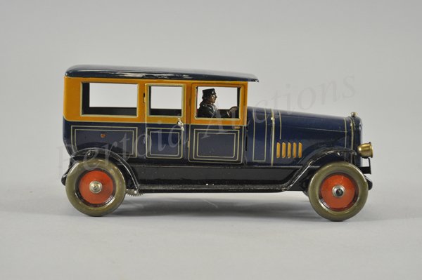 DISTLER LIMOUSINE: Germany, c. 1928, beautiful lithographed tin color scheme, blue and yellow body, black fenders with running boards, clockwork driven, seated chauffeur wears overcoat, opening passenger doors. 10" l.
