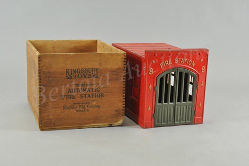 KINGSBURY AUTOMATIC FIRE STATION WITH ORIGINAL BO: No. 8823, pressed steel, painted in red with green front bay doors, clockwork allows bell ringing and doors to fling open as if there was a fire call, sides embossed in brick pattern. 10" h. x 9" w. x