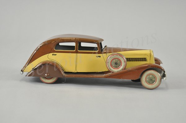 CHARLES ROSSIGNOL PEUGEOT SEDAN: c. 1930's, streamlined deco beauty, lithographed tin, done in brown and yellow body with spare wheels mounted on ornate curved fenders, clockwork driven. 14" l.