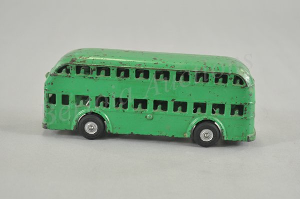ARCADE DOUBLE DECKER BUS: A scarce example, painted green with black rubber tires, double decker features open windows on both levels, red spots painted on rear for stop lights. 8" l.