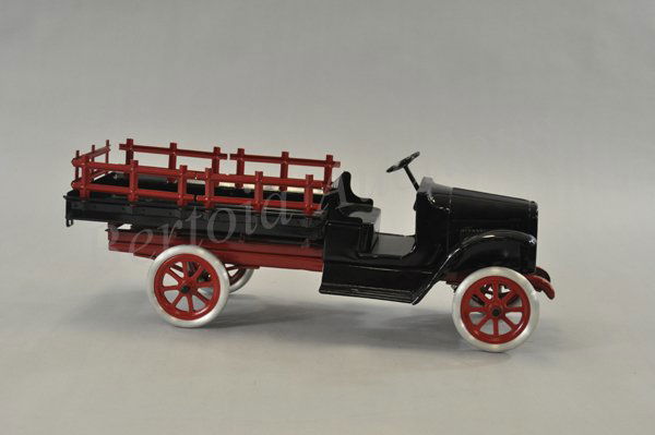 BUDDY "L" STAKE TRUCK: c. 1923, pressed steel, low open cab painted in black, maroon chassis and removable stake sides, fold down tail gate, aluminum spoke wheels, early model. 25" l.