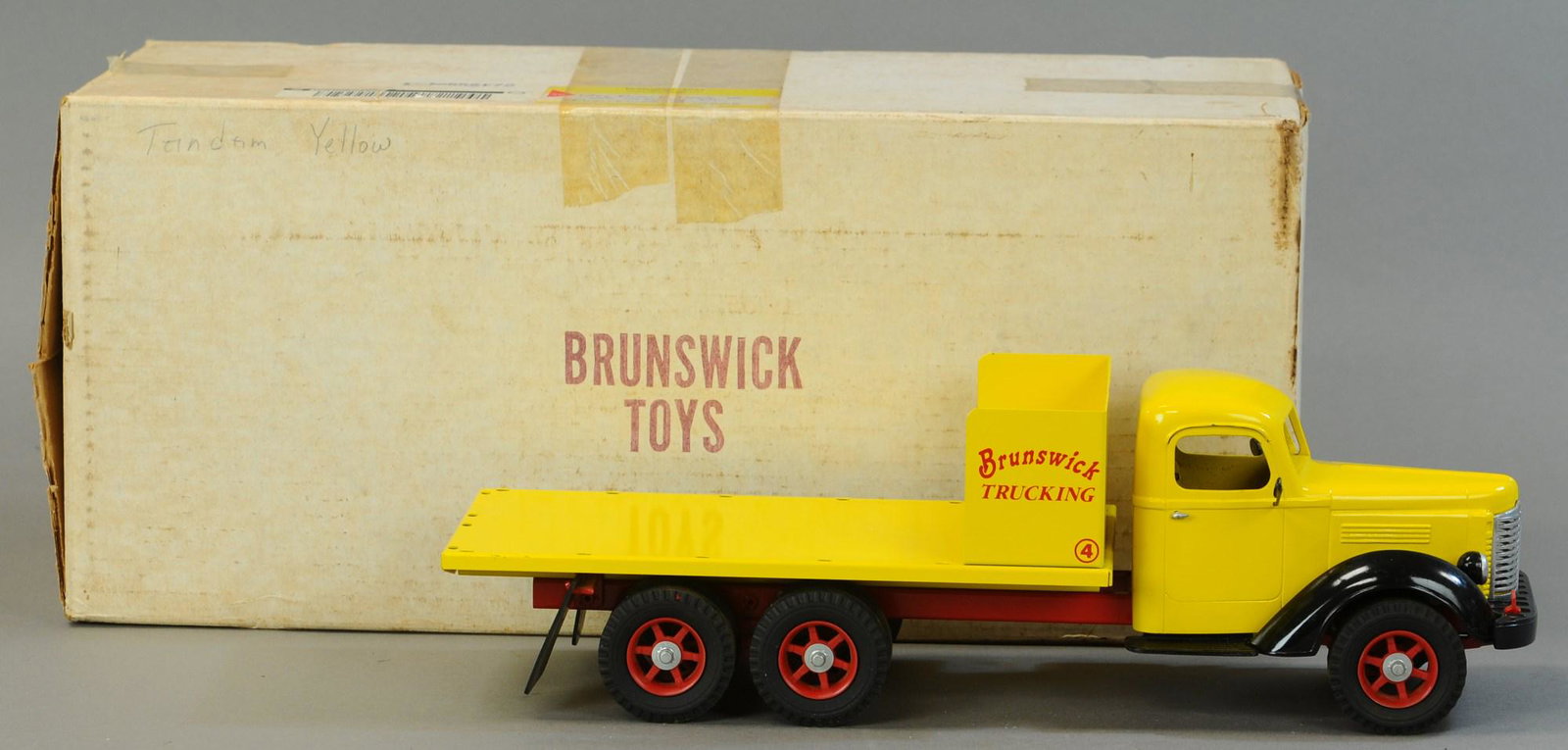 BOXED BRUNSWICK TOYS INTERNATIONAL FLATBED: 569. BOXED BRUNSWICK TOYS INTERNATIONAL FLATBED | 18" l. | Missing stakes for flat bed sides, dash board and steering wheel present but disconnected. | $150 - $300