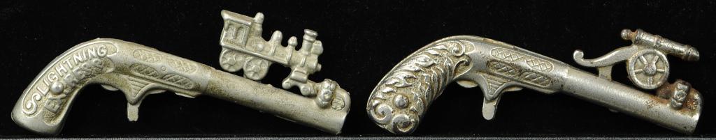 LIGHTING EXPRESS & CANNON ANIMATED CAP GUNS: 895. LIGHTING EXPRESS & CANNON ANIMATED CAP GUNS | Train and cannon slide across the top of barrel to explode cap on each gun. Provenance: The Schroeder Collection. | 5" l. | (Excellent Condition) | $