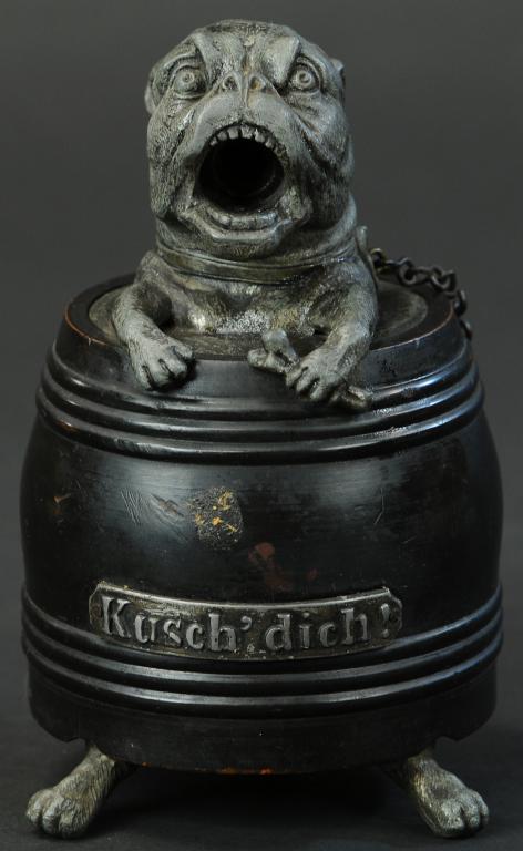 DOG IN BARREL FIGURAL CIGAR CUTTER: 906. DOG IN BARREL FIGURAL CIGAR CUTTER | When dog's legs are pushed up, it cuts the cigar in the dog's mouth, figure is Spelter and has wooden barrel. Provenance: The Schroeder Collection. | 7" h. | 