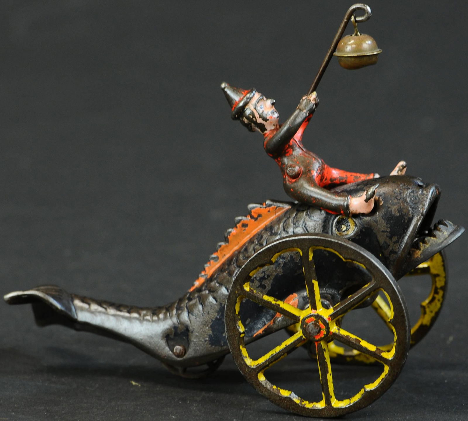 CLOWN & THE FISH BELL TOY: 955. CLOWN & THE FISH BELL TOY | Gong Bell, a whimsical design, as toy is pulled along, Clown attempts to feed a metal bell to the fish with an animating open mouth. Provenance: The Schroeder Collecti