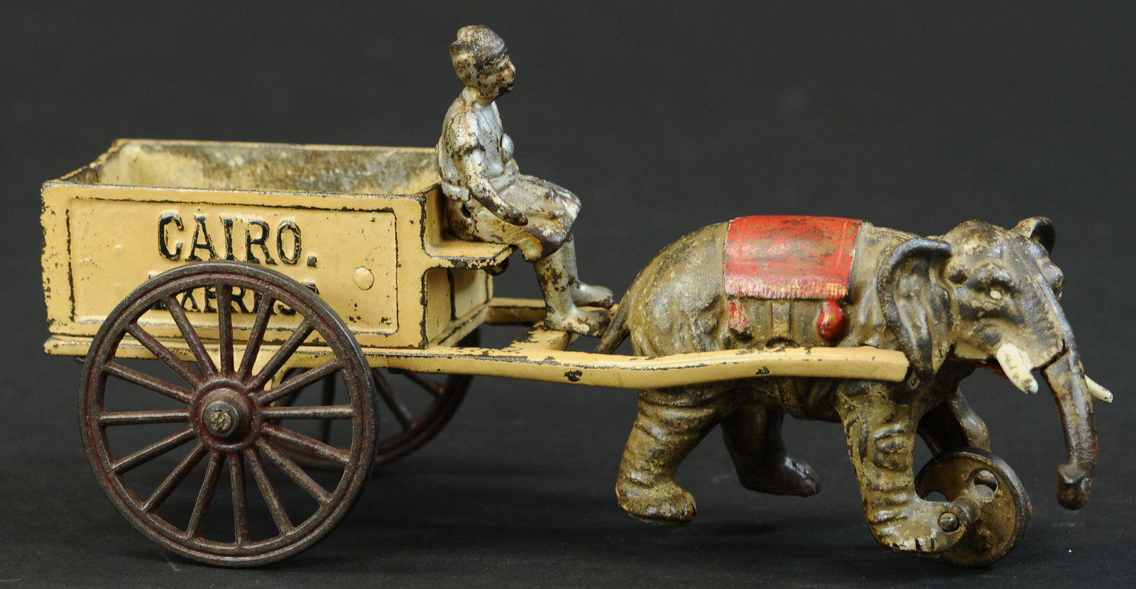 KENTON CAIRO EXPRESS ELEPHANT CART: 981. KENTON CAIRO EXPRESS ELEPHANT CART | Desirable casting of a single elephant drawn toy with seated native figure on open cart. Provenance: The Schroeder Collection. | 10" l. | Original figure & el