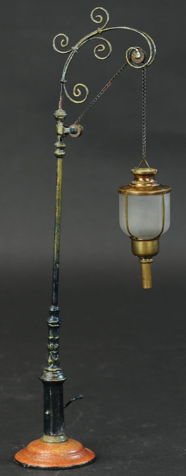 MARKLIN NO. 3055 HANGING LAMP: 1311. MARKLIN NO. 3055 HANGING LAMP | Hand painted post, nickel lamp shade, clear glass globe, circa 1902, catalog #3055. | 16.5" h. | Provenance: Paul Cole Collection. | Base restored, top of arch re