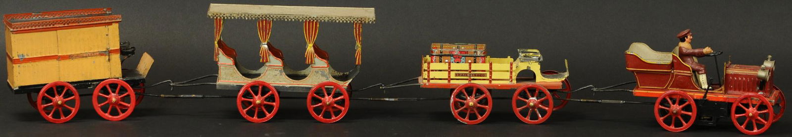 FRENCH LE TRAIN RENARD SET: 886. FRENCH LE TRAIN RENARD SET | Early wind-up automotive tractor driven train with three cars, a very popular cross over between trains and automotive toy collectors. | 10.5" l. | Provenance: Paul C