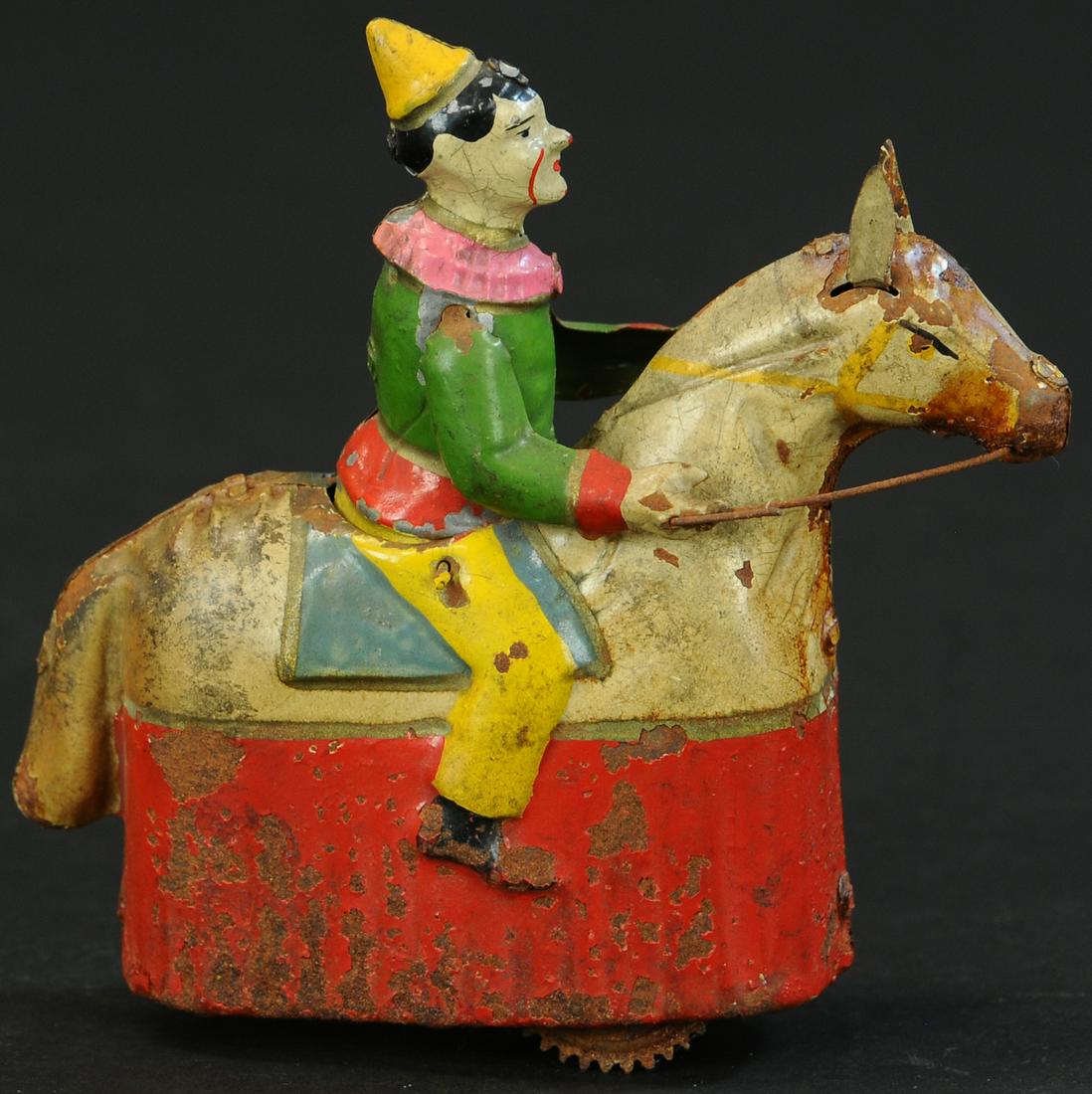HANS EBERL CLOWN RIDING WIND-UP CIRCUS HORSE: 74. HANS EBERL CLOWN RIDING WIND-UP CIRCUS HORSE | 6" h. | Oxidation to unpainted underside of toy, more wear to one side of toy than other, (Very Good Cond.) | $800 - $1,200