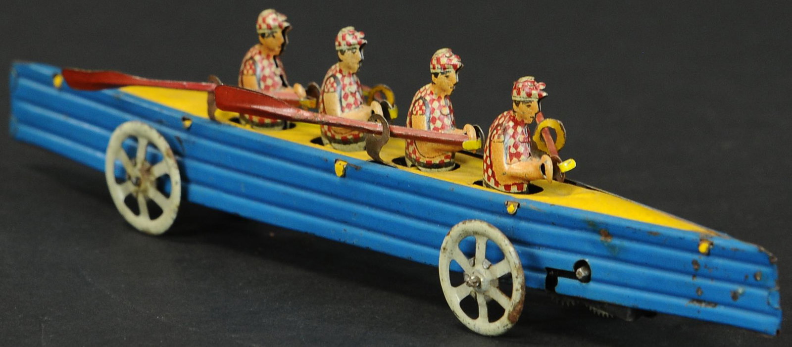 FOUR MAN RACE SCULLL PENNY TOY: 297. FOUR MAN RACE SCULLL PENNY TOY | 9" l. | One oar is replaced, otherwise in overall (Exc. Cond.) | $500 - $750