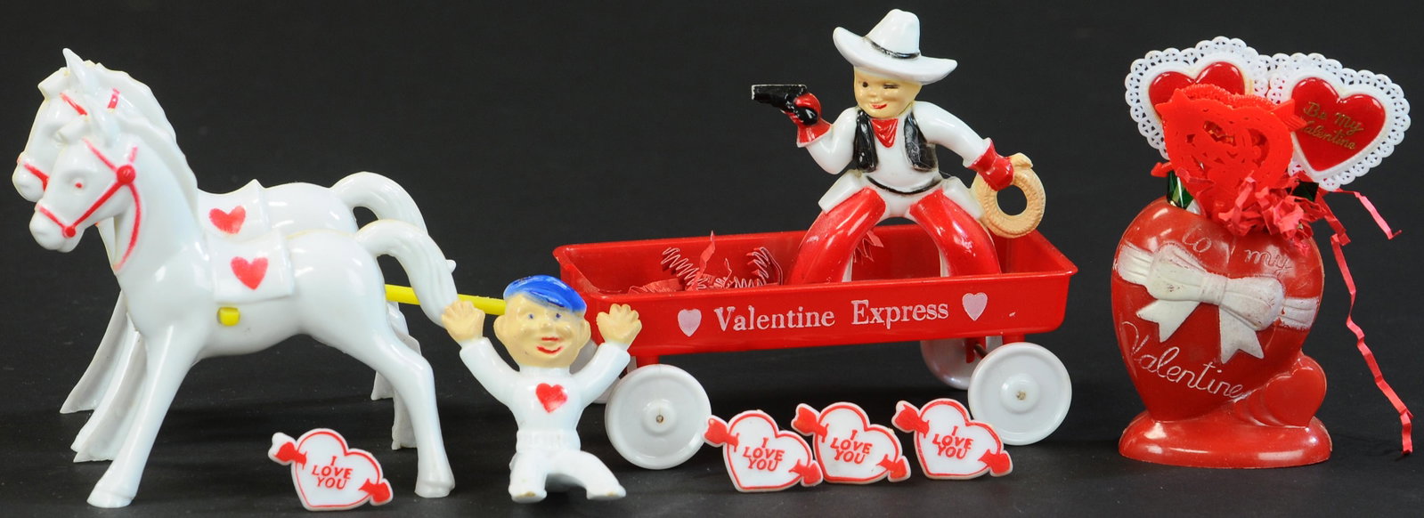 ROSBRO VALENTINE HORSE DRAWN WAGON, COWBOY & HEART: 1190. ROSBRO VALENTINE HORSE DRAWN WAGON, COWBOY & HEART | A lollipop heart and a cowboy on a white horse, pulling a wagon. | 3" h. heart; 10" h. wagon | Supports for wagon's front wheels are broken, 