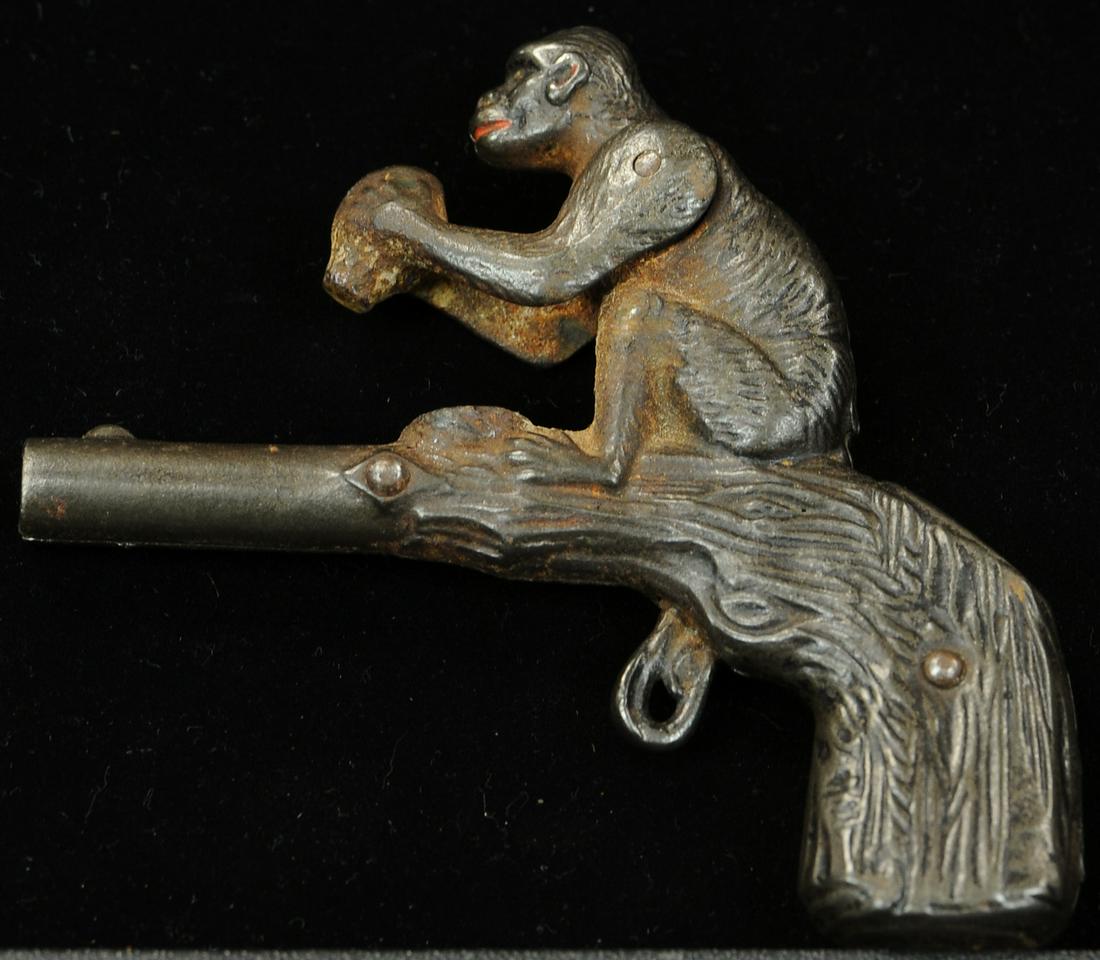 STEVENS MONKEY WITH COCONUT ANIMATED CAP GUN: 1596. STEVENS MONKEY WITH COCONUT ANIMATED CAP GUN | 4" h. | Chip at bottom of hand grip, overall (VG - Exc. Cond.) | $200 - $400