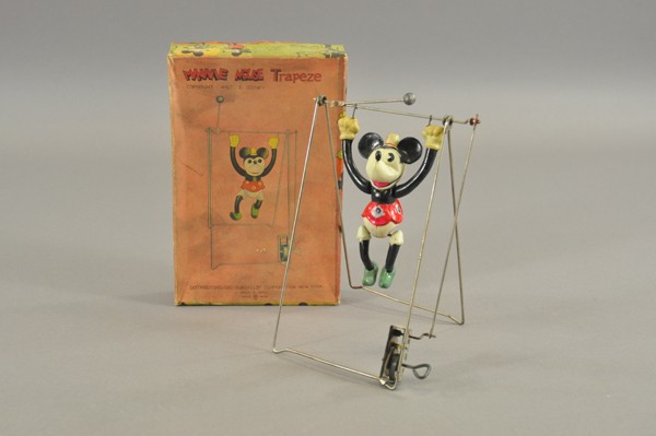 MINNIE MOUSE TRAPEZE WITH ORIGINAL BOX: Japan, Geo. Borgfeldt Dist., early celluloid figure of Minnie on wire frame with bars, clockwork mechanism. 8 1/4" h.