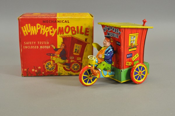 HUMPHREY MOBILE WITH ORIGINAL BOX: Wyandotte, lithographed tin, features Humphrey seated on three-wheeler bringing his house along with him & creating an early example of a "mobile" home. Excellent details and very colorful graphics, c